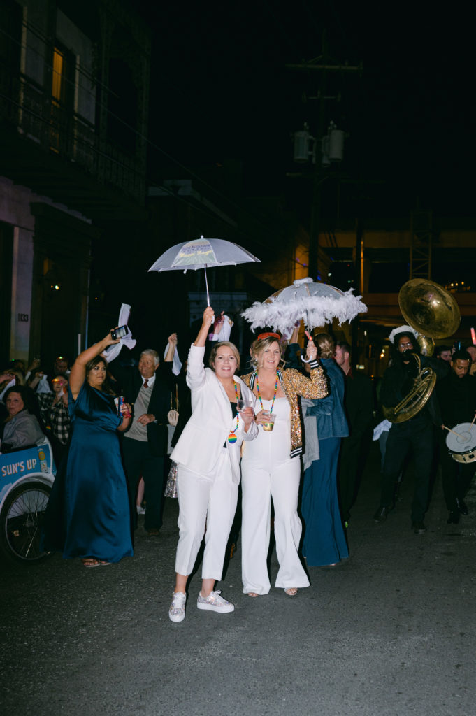 LGBTQ+ couple celebrating in a Second Line Parade after being married.